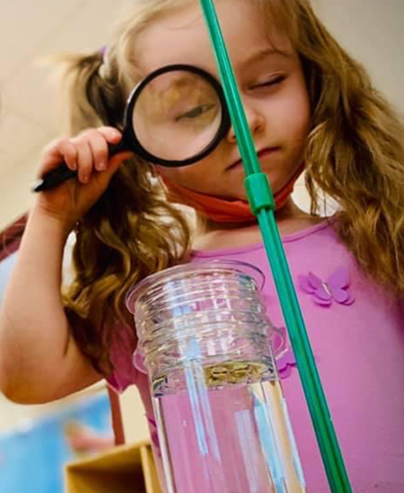 Girl Looking with magnifying glass